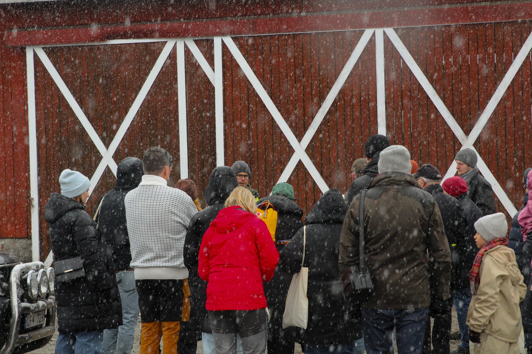 En grupp människor utomhus utanför en lada