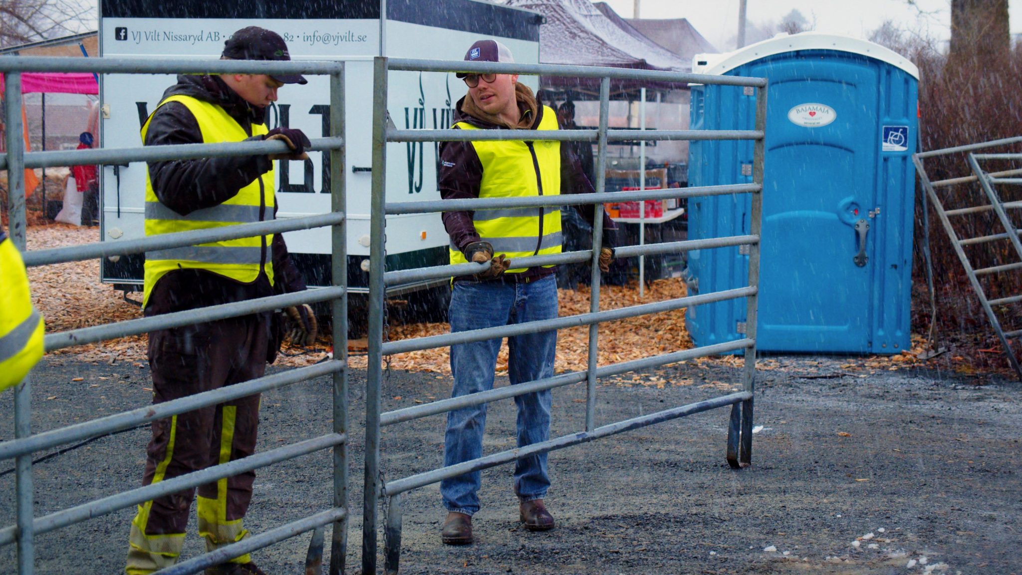 Personal som flyttar en grind utomhus