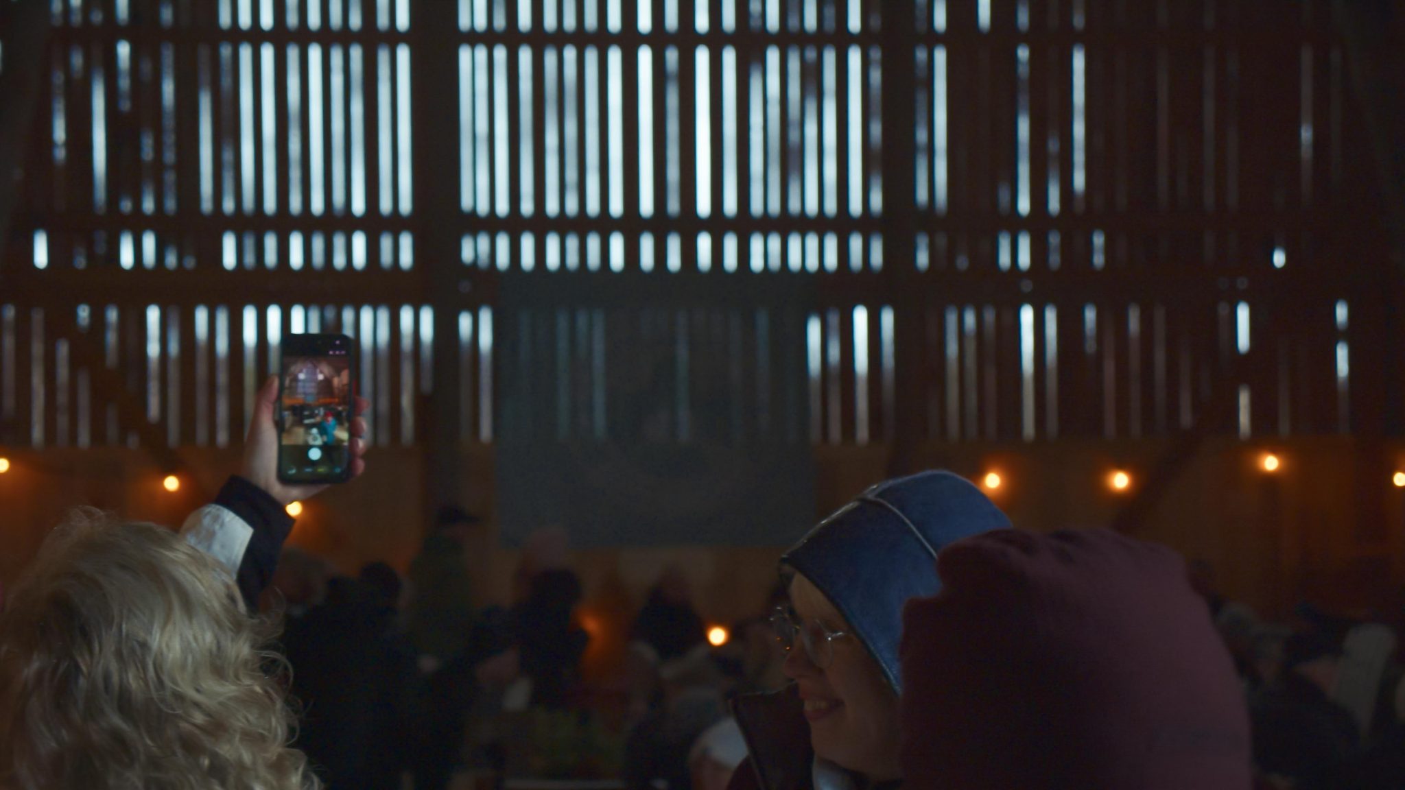 En äldre dam som ler inomhus i logen