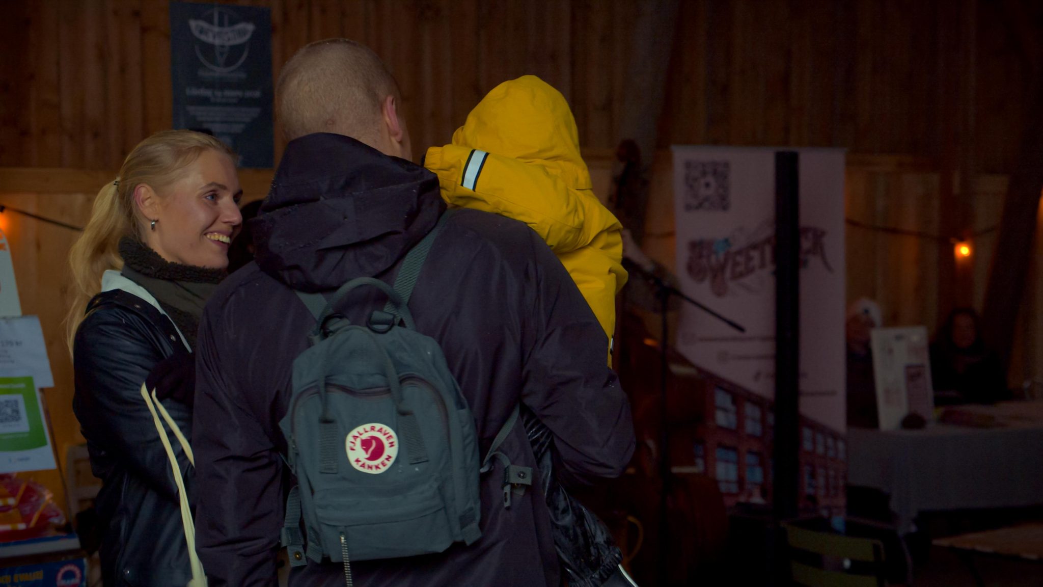 Ett par som håller i ett barn med en gul jacka på