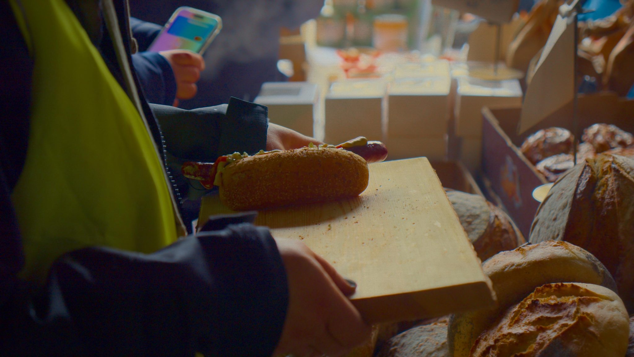 En person som håller i en korv på en bricka