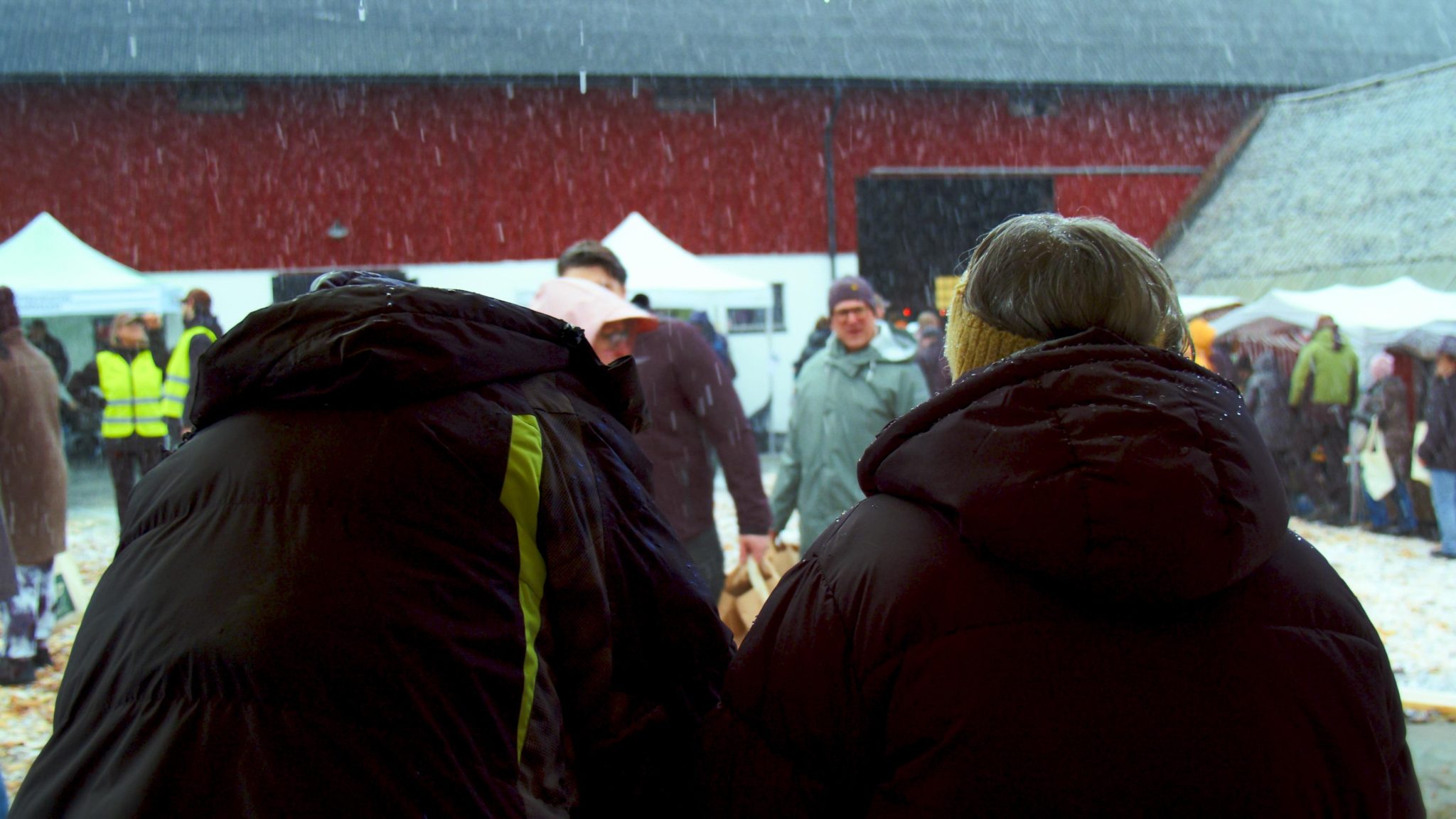 Två personer som tittar ut och det snöar