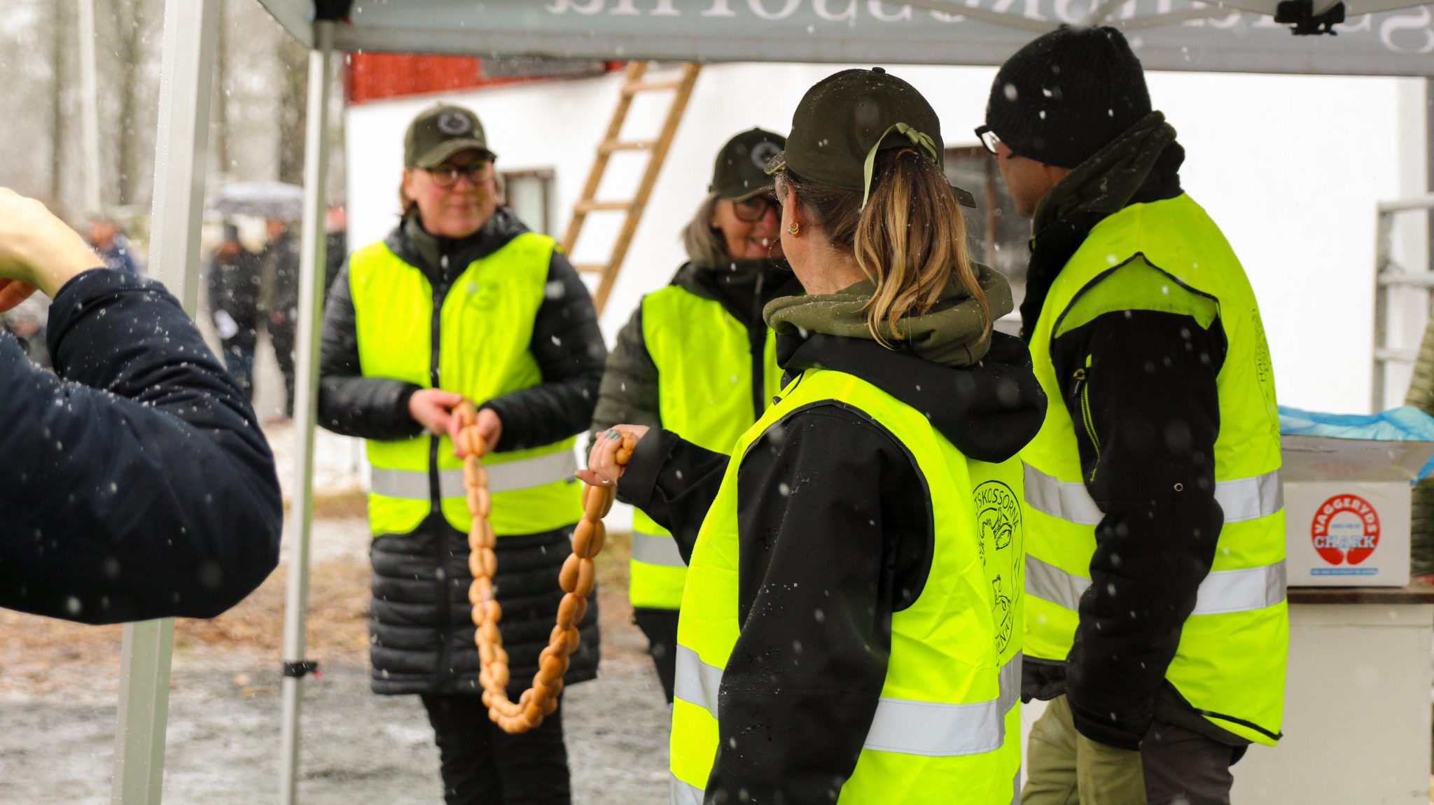 Personal som håller i ett band av korv