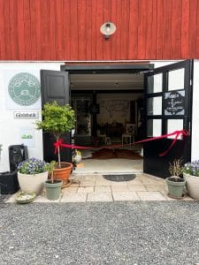 Gårdsbutik med rött band framför ingången
